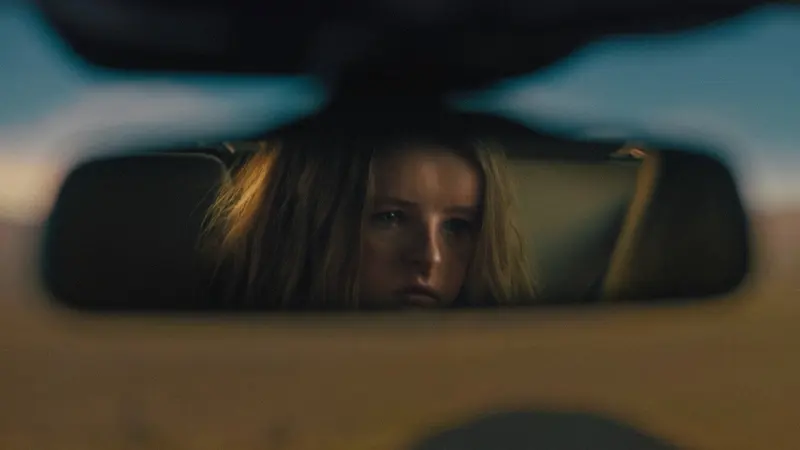Toni Collette's daughter reflected in a car's rear-view mirror in Hereditary