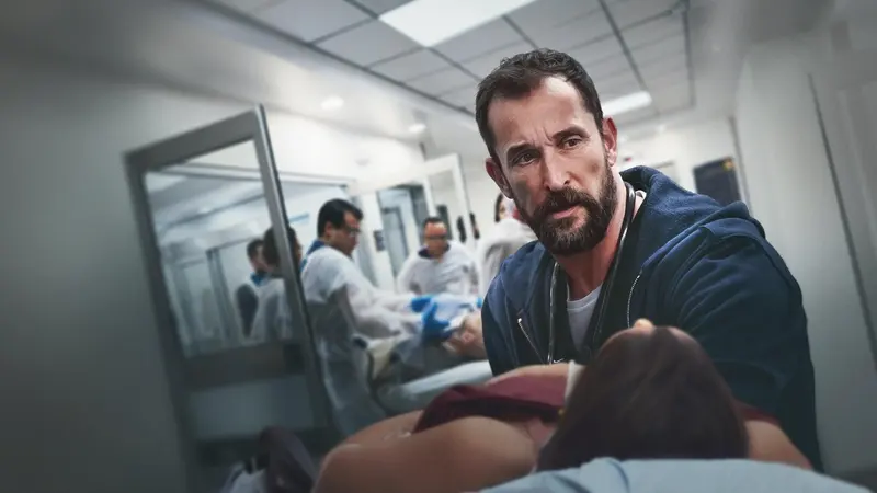 Noah Wyle as Dr. Robby treating a patient in the emergency room in The Pitt