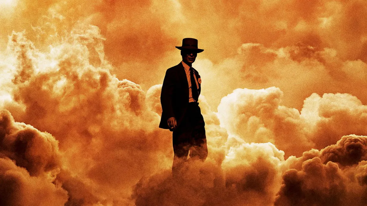 Cillian Murphy as J. Robert Oppenheimer silhouetted against fiery clouds in Oppenheimer key art