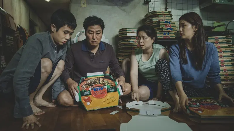 The Kim family folding pizza boxes in their semi-basement home in Parasite